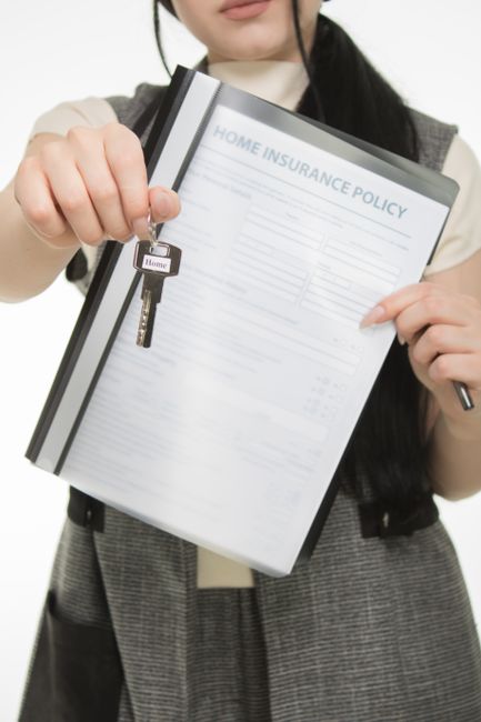 A young woman with blonde hair dressed in a casual green t-shirt and ripped blue jeans, holding a clipboard and pen while inspecting a room prepared for end of tenancy cleaning. She is standing on a l